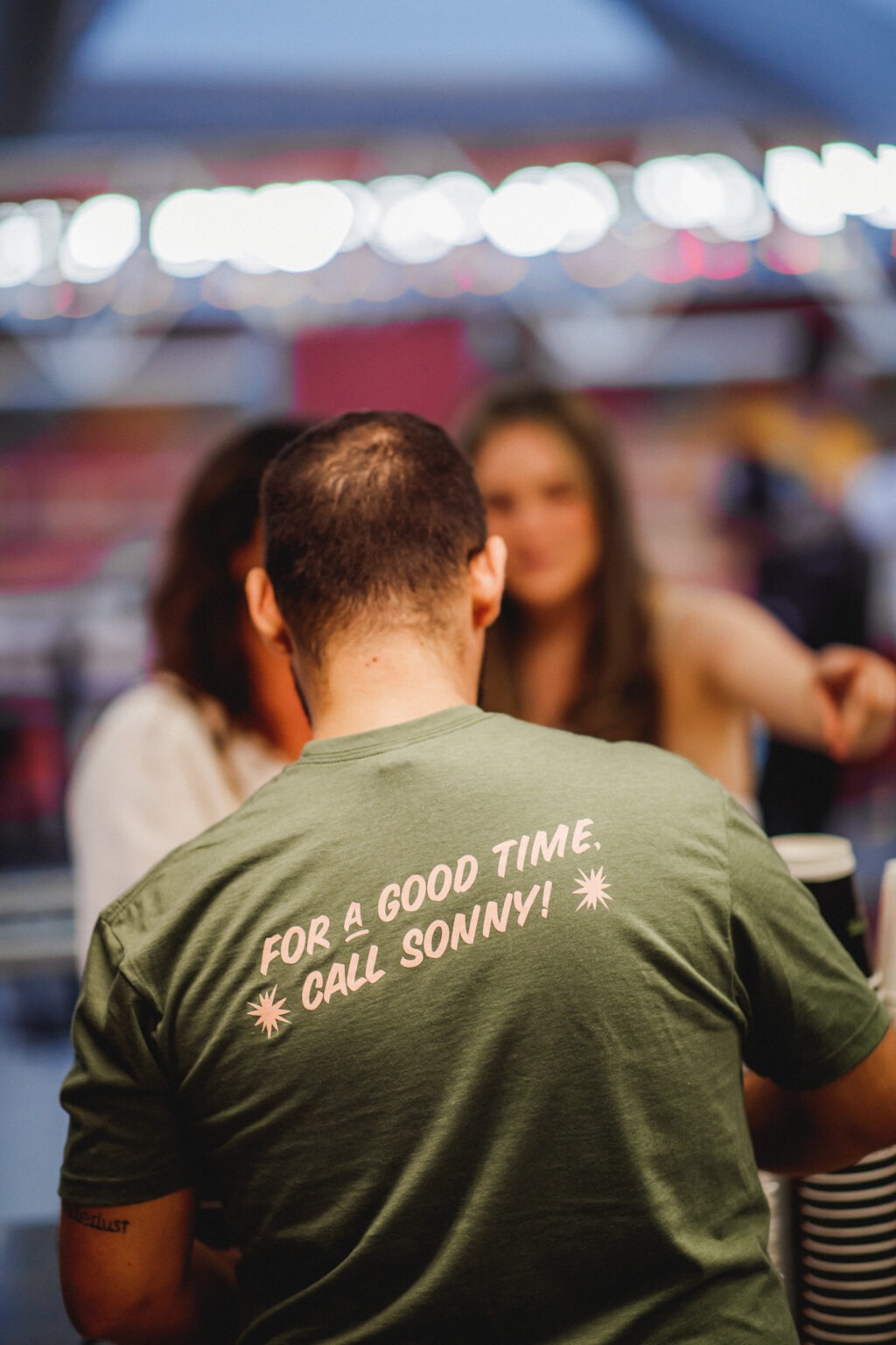 Bartender with branded shirt serving customers