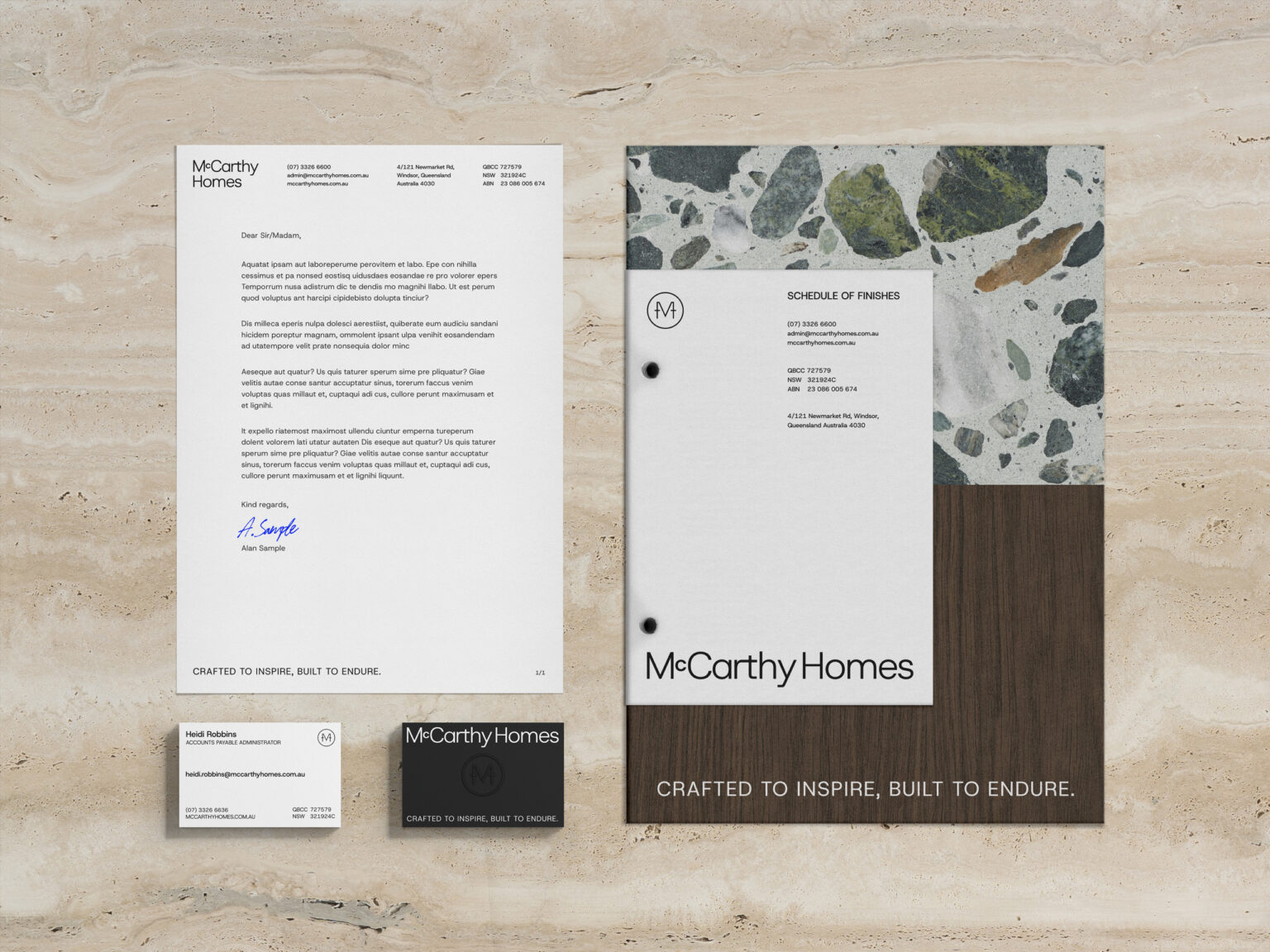 McCarthy Homes brand identity mockup displaying letterhead, business card, and materials samples on marble background.